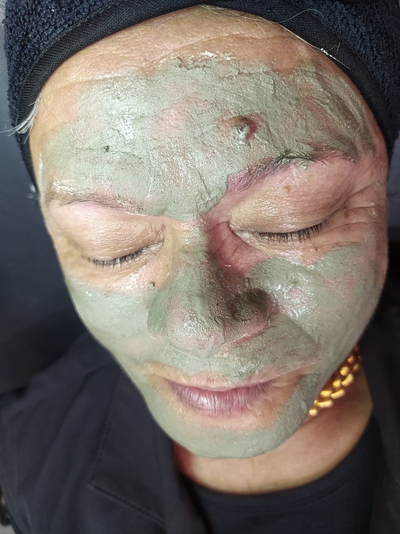 Cliente com máscara de argila durante a limpeza de pele